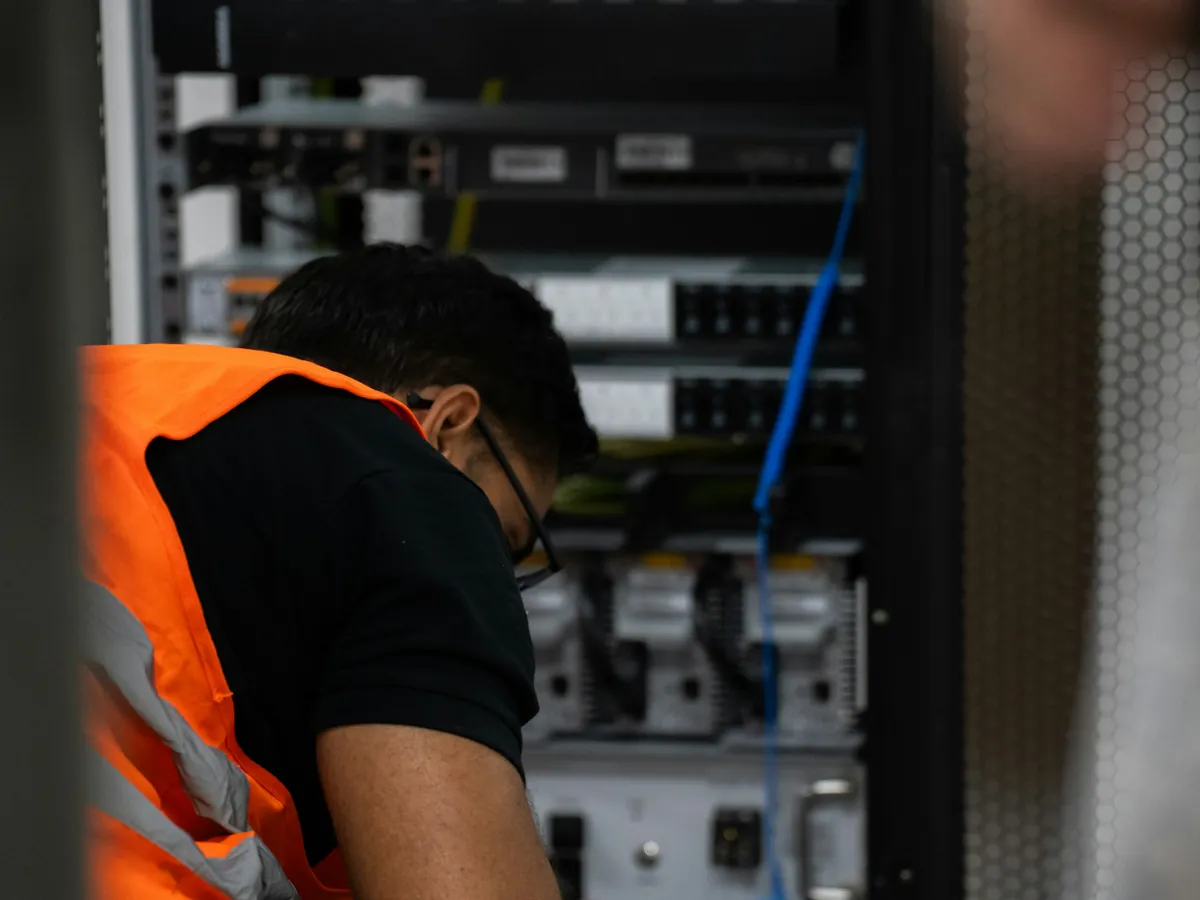 A TIO IT engineer working in a comms room